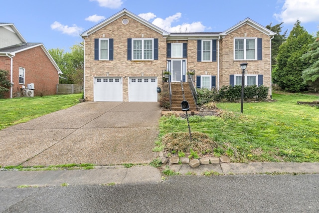 split foyer home featuring a front yard, a garage, brick siding, and concrete driveway