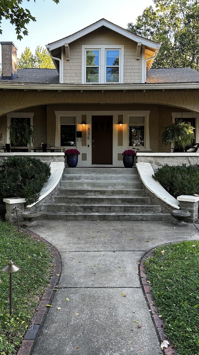 336 Chesterfield Ave, Nashville, TN 37212 - view of exterior entry with covered porch, roof with shingles, and a chimney
