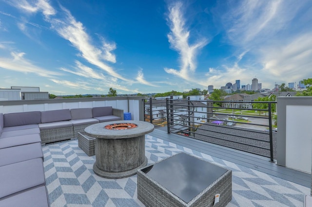 view of patio featuring an outdoor living space with a fire pit, a balcony, and a view of city