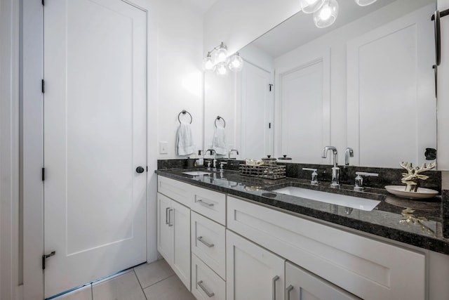full bath featuring double vanity, a sink, and tile patterned floors