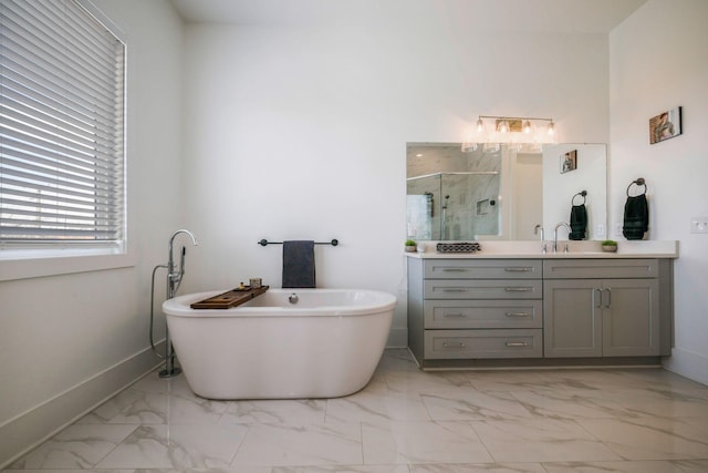bathroom featuring a soaking tub, a shower stall, baseboards, marble finish floor, and vanity