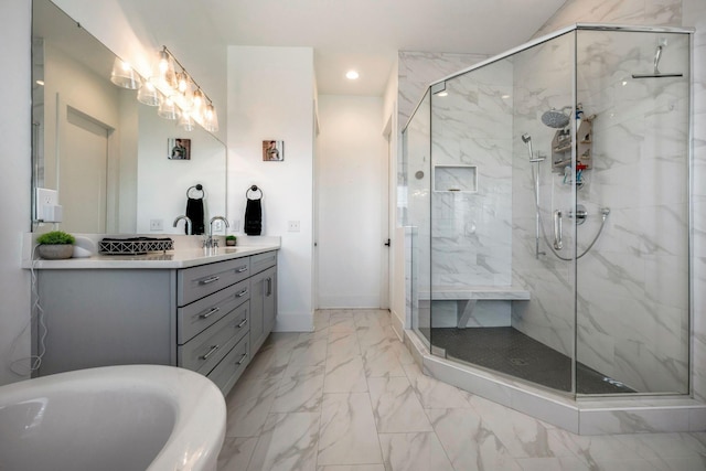 bathroom with a freestanding tub, vanity, a marble finish shower, marble finish floor, and recessed lighting