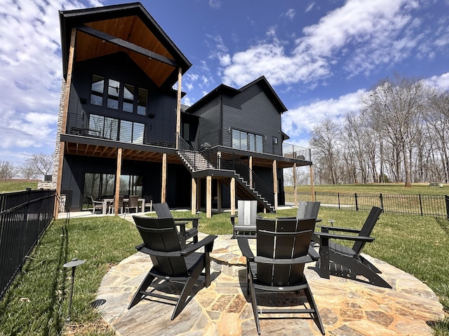 rear view of property featuring stairway, a fenced backyard, a patio, a lawn, and an outdoor fire pit