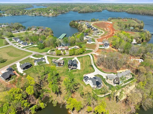 birds eye view of property featuring a water view and a wooded view