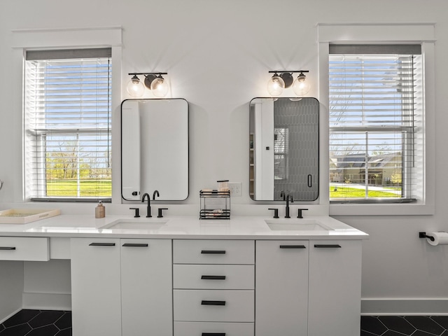 bathroom featuring tile patterned floors, baseboards, and a sink