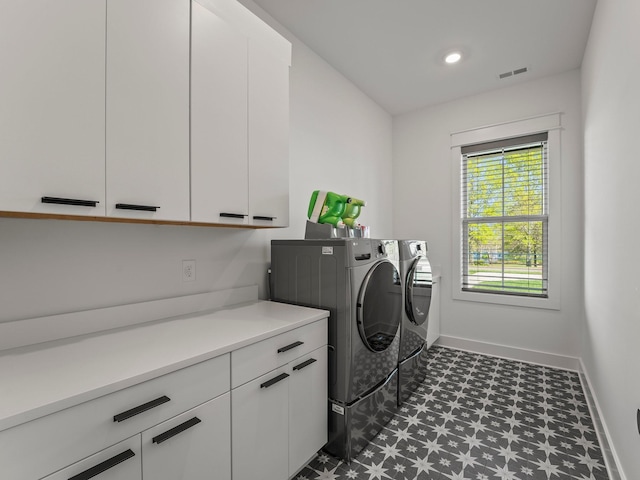 laundry room with baseboards, visible vents, cabinet space, dark floors, and washer and dryer