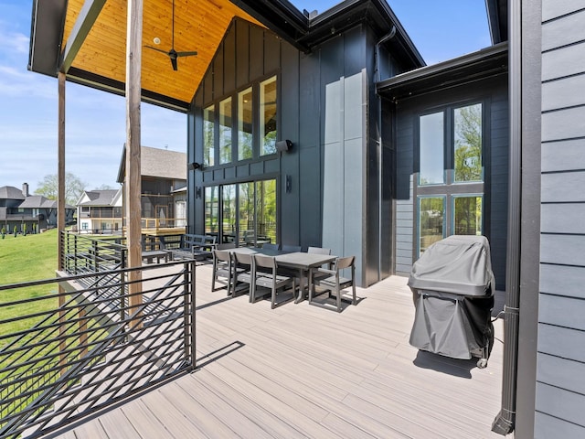 deck with outdoor dining area, a ceiling fan, and area for grilling