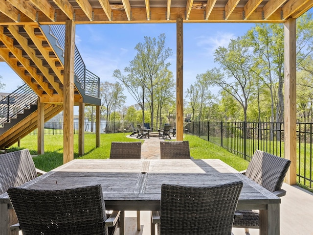 view of patio / terrace with a fenced backyard, stairway, and outdoor dining space