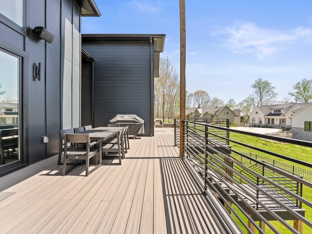 deck featuring a residential view, outdoor dining space, and area for grilling