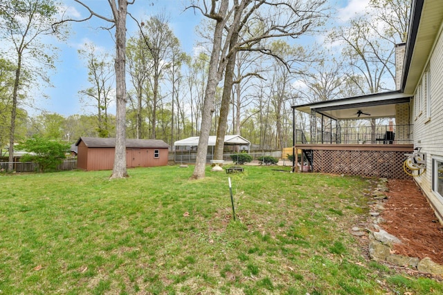 view of yard with an outbuilding, a fenced backyard, and ceiling fan