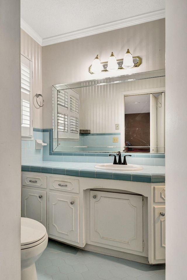 bathroom with vanity, crown molding, toilet, and decorative backsplash