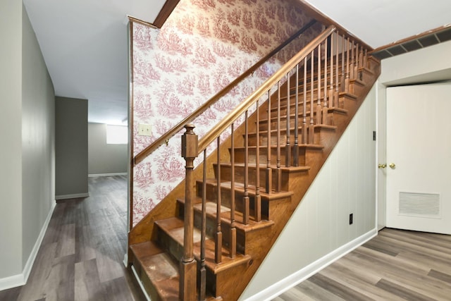 stairs featuring visible vents, baseboards, and wood finished floors