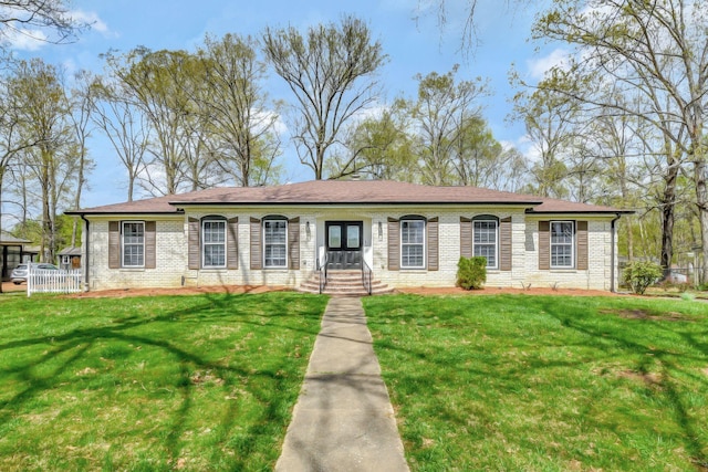 ranch-style house featuring a front yard and brick siding