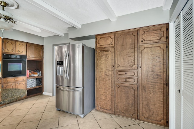 kitchen featuring light tile patterned flooring, oven, stainless steel fridge with ice dispenser, and beamed ceiling