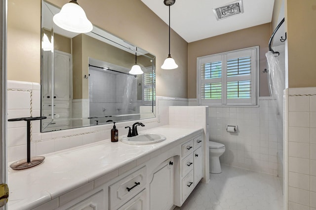 bathroom with vanity, tile patterned flooring, visible vents, toilet, and tile walls