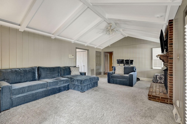 carpeted living area with ceiling fan, a fireplace, and vaulted ceiling with beams