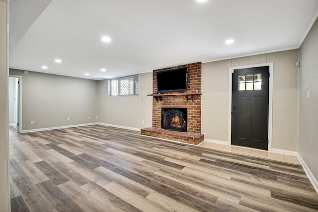 unfurnished living room featuring wood finished floors, a fireplace, baseboards, and recessed lighting