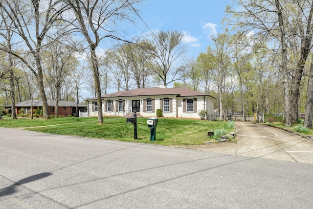 view of front of house with a front yard and concrete driveway