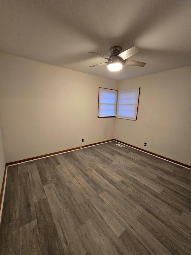 unfurnished room featuring baseboards, wood finished floors, and a ceiling fan