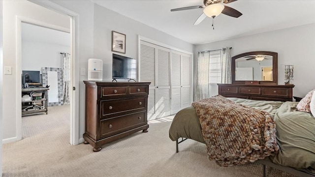 bedroom featuring light colored carpet, a closet, and a ceiling fan
