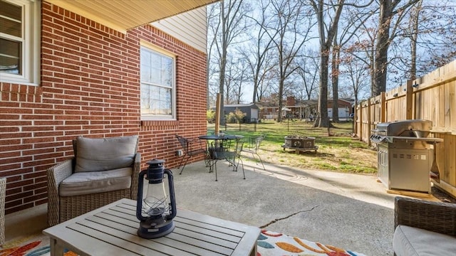 view of patio featuring an outdoor fire pit, outdoor dining space, area for grilling, and fence