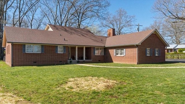 back of house with crawl space, a chimney, brick siding, and a yard