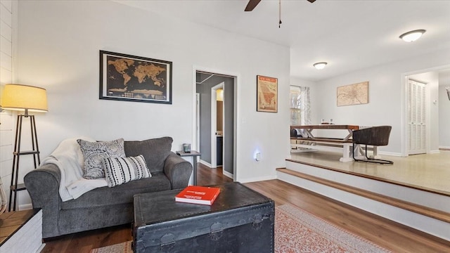 living room with baseboards, wood finished floors, and a ceiling fan
