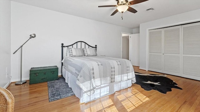 bedroom with visible vents, a closet, wood finished floors, and ceiling fan