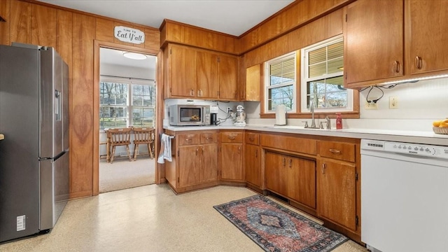 kitchen featuring a sink, light countertops, brown cabinets, and appliances with stainless steel finishes
