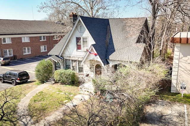 3524 W End Ave, Nashville, TN 37205 - tudor-style house featuring stone siding, a chimney, stucco siding, and roof with shingles