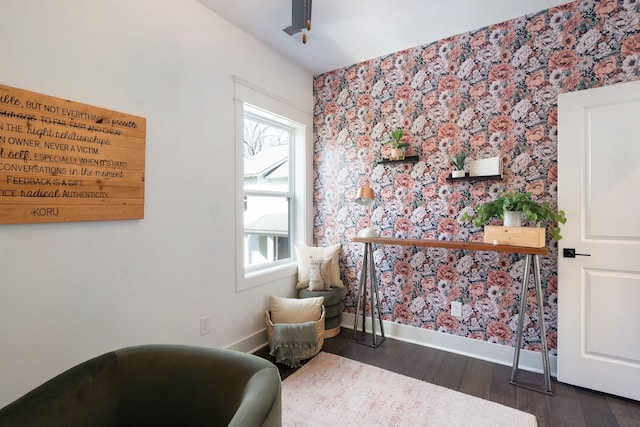sitting room featuring wallpapered walls, baseboards, and wood finished floors