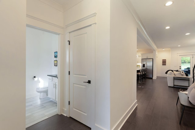 corridor featuring dark wood-style flooring, recessed lighting, and baseboards