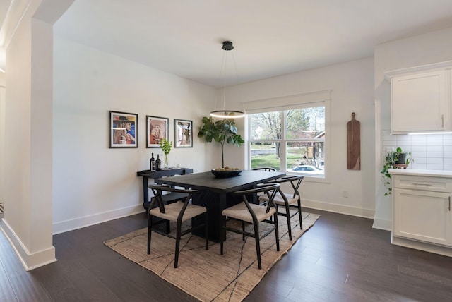 dining room with dark wood-type flooring and baseboards