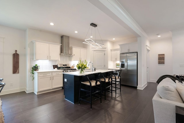 kitchen featuring stainless steel appliances, wall chimney exhaust hood, a sink, light countertops, and white cabinetry