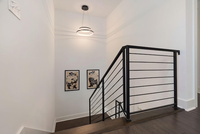 stairs featuring wood finished floors and baseboards