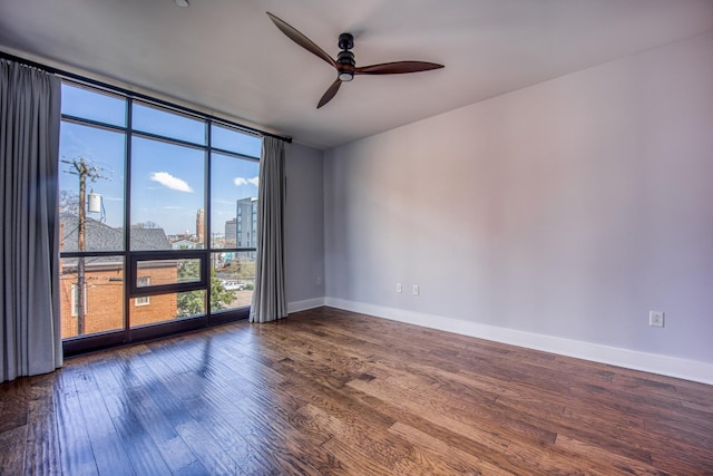 3000 Poston Ave Unit 102, Nashville, TN 37203 - spare room with baseboards, wood finished floors, a ceiling fan, expansive windows, and a view of city