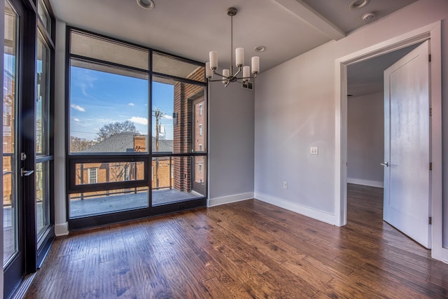 3000 Poston Ave Unit 102, Nashville, TN 37203 - empty room featuring baseboards, expansive windows, an inviting chandelier, and hardwood / wood-style flooring