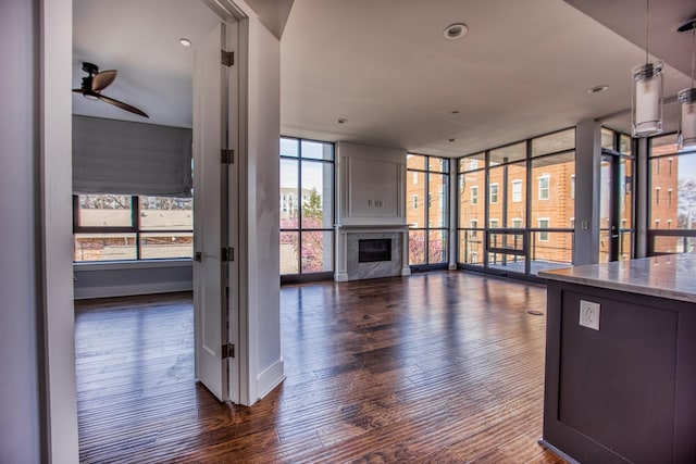3000 Poston Ave Unit 102, Nashville, TN 37203 - unfurnished living room featuring expansive windows, a ceiling fan, a premium fireplace, and dark wood-style floors