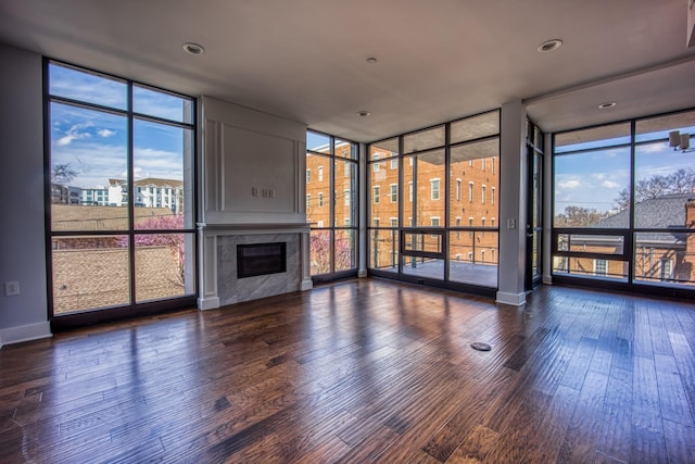 3000 Poston Ave Unit 102, Nashville, TN 37203 - unfurnished living room featuring baseboards, wood finished floors, a premium fireplace, and a wall of windows