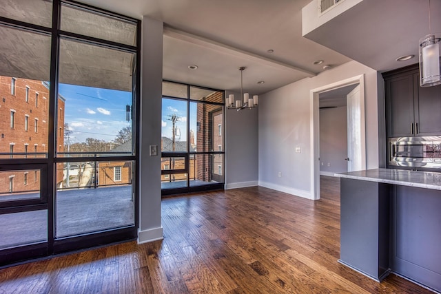 3000 Poston Ave Unit 102, Nashville, TN 37203 - interior space featuring a wall of windows, stainless steel microwave, baseboards, dark wood-style floors, and light stone countertops