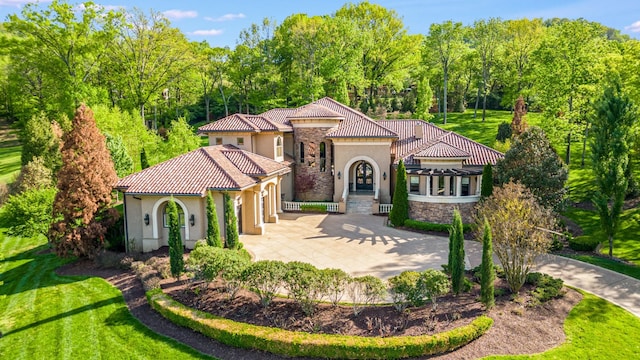 947 Tyne Blvd, Nashville, TN 37220 - mediterranean / spanish home featuring stone siding, a garage, concrete driveway, a front lawn, and stucco siding