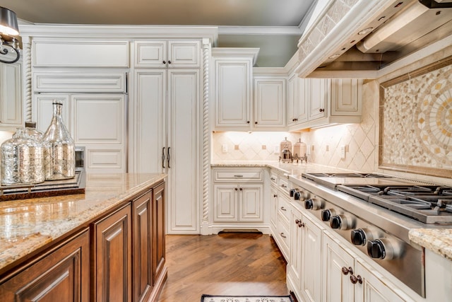 947 Tyne Blvd, Nashville, TN 37220 - kitchen featuring stainless steel gas stovetop, ornamental molding, wood finished floors, premium range hood, and backsplash