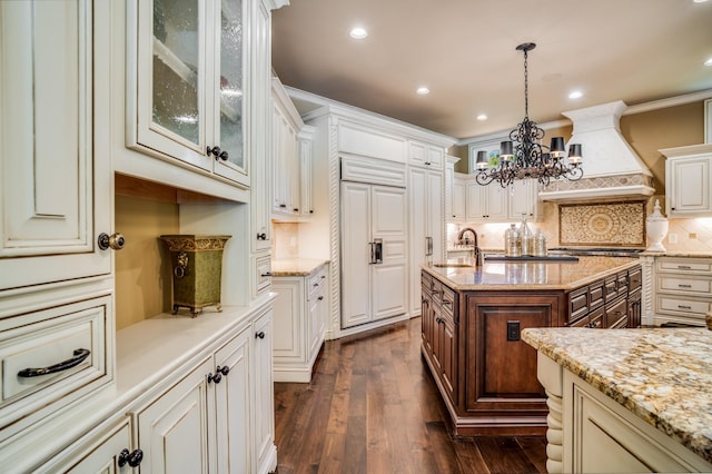 947 Tyne Blvd, Nashville, TN 37220 - kitchen with custom range hood, an inviting chandelier, dark wood finished floors, a sink, and light stone counters