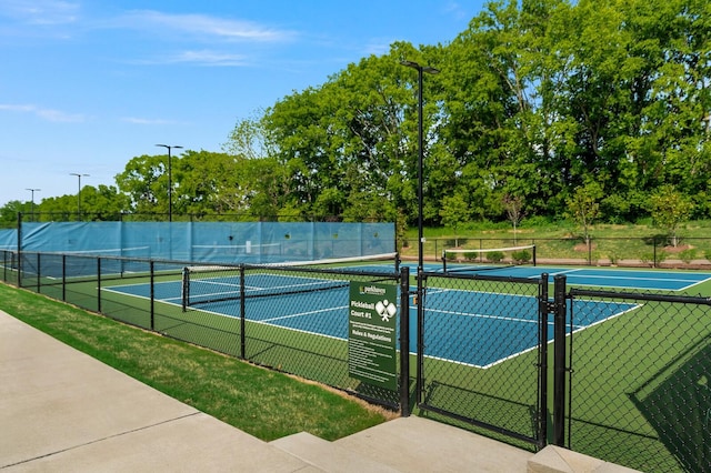 view of tennis court featuring a gate and fence
