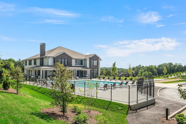 community pool with fence and a yard