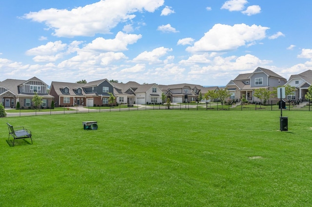 surrounding community with a residential view, fence, and a lawn