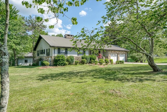 5651 S York Hwy, Grimsley, TN 38565 - single story home featuring metal roof, stone siding, an attached garage, a front lawn, and a chimney