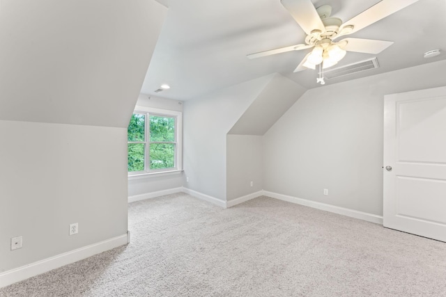 additional living space featuring visible vents, carpet, baseboards, a ceiling fan, and vaulted ceiling