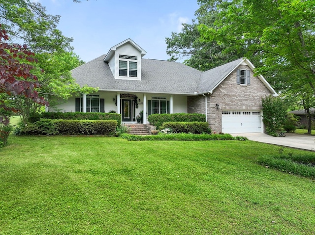 new england style home featuring roof with shingles, concrete driveway, a garage, a front lawn, and a porch