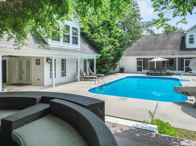 outdoor pool featuring french doors, a water slide, and a patio area